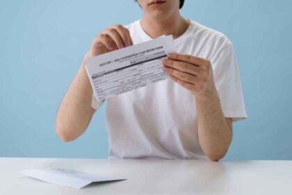 Persona sosteniendo y leyendo un documento tipo resultado o formulario de prueba de VIH, en un entorno clínico.