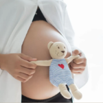 mujer embarazada con osito de peluche