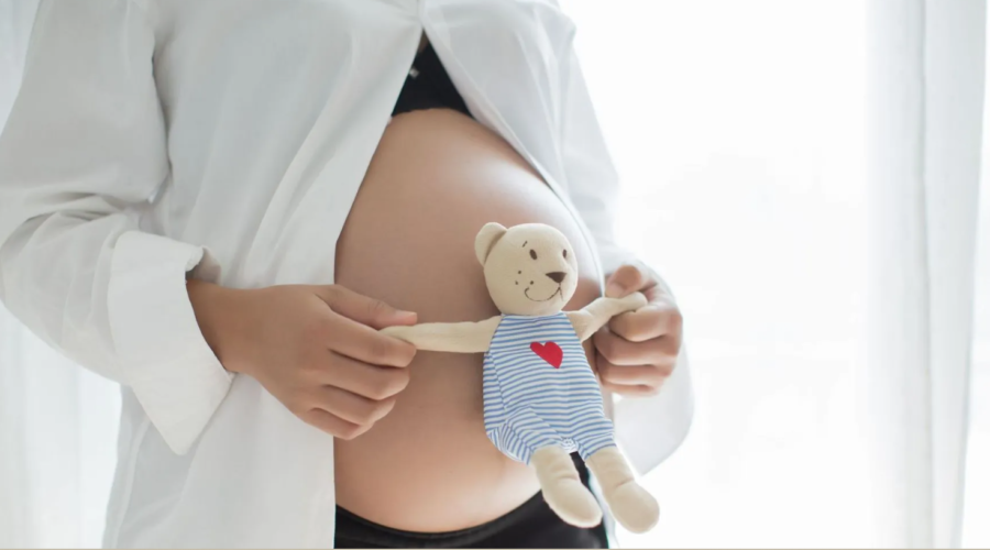 mujer embarazada con osito de peluche