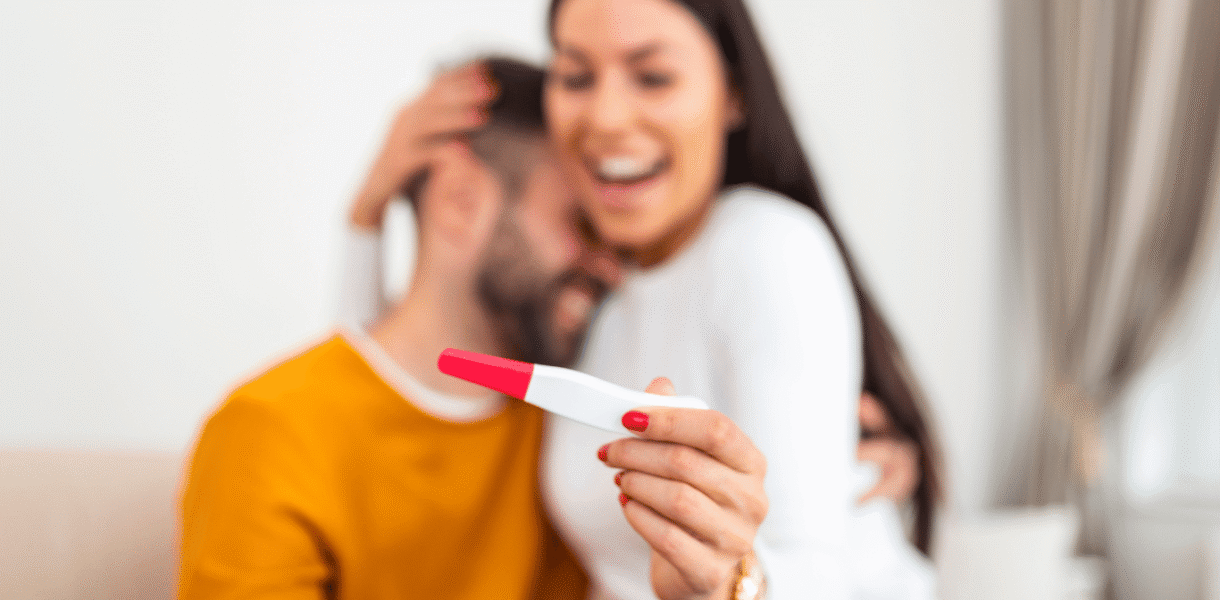 pareja feliz con prueba de embarazo